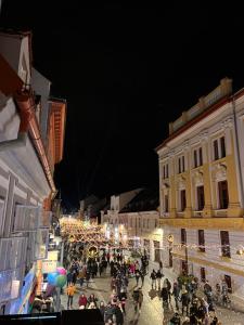 a crowd of people walking down a street at night at Artist Apartment in Braşov