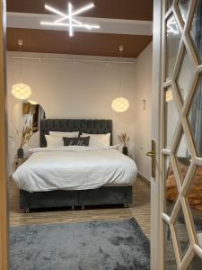 a bedroom with a large bed and two lights at Artist Apartment in Braşov