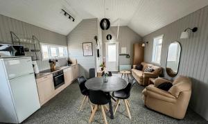 a kitchen and a living room with a table and chairs at Garður Apartments in Gardur