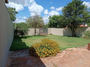 a yard with a fence and a flower bush at Casa Ana in Dourados