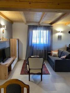 a living room with a couch and a tv and a window at Holiday house with a parking space Cujica Krcevina, Plitvice - 20257 in Plitvička Jezera