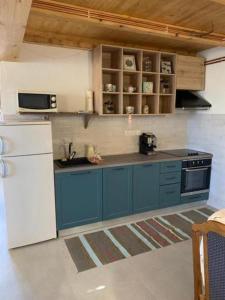 a kitchen with blue cabinets and a white refrigerator at Holiday house with a parking space Cujica Krcevina, Plitvice - 20257 in Plitvička Jezera