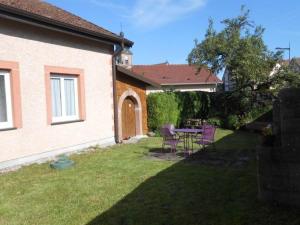 a yard with a table and chairs and a house at Maison Vosgienne Charmante: 2 Chambres, Cheminée, Proche Gérardmer, Parfaite pour Familles et Fêtes - FR-1-589-36 in Corcieux