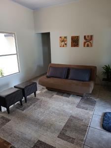 a living room with a brown couch and a window at Casa Ana in Dourados