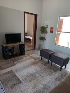 een woonkamer met een flatscreen-tv en een bank bij Casa Ana in Dourados
