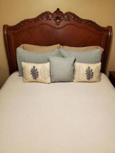 a bed with a wooden head board and pillows at Hampton House in Clinton