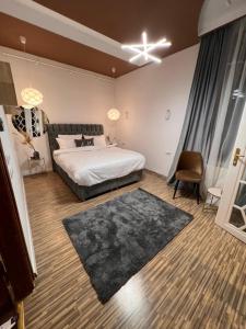 a bedroom with a large bed and a black rug at Artist Apartment in Braşov