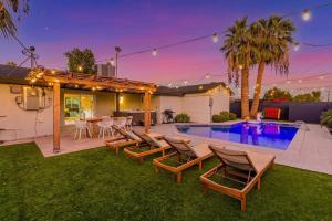 a backyard with a pool and chairs and a house at Galactic Getaway by Scottsdale Beach Club - NEW in Scottsdale