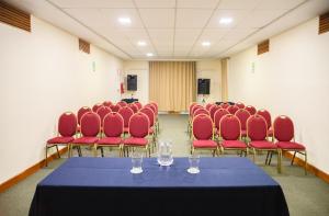 una sala conferenze con sedie rosse e un tavolo con bicchieri da vino di Hotel Presidente Huancavelica - Asociado Casa Andina a Huancavelica
