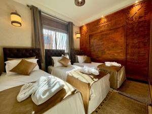 um quarto de hotel com duas camas com toalhas em Hotel Apartments Lexpert em Merzouga