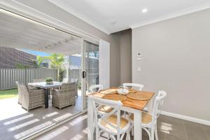 a dining room with a table and chairs at Cathie 29 in Port Macquarie