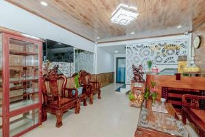 - un salon avec des chaises, une table et un mur dans l'établissement Moc Nhien Hostel Da Lat, à Đà Lạt