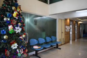 a christmas tree in a hospital hallway with blue chairs at The Boni Tower by RSPL Manila City Center in Manila