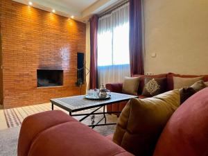 a living room with two couches and a table at Hotel Apartments Lexpert in Merzouga