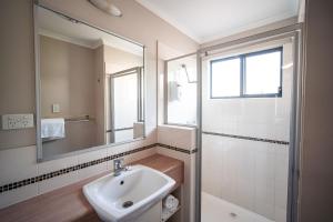 a bathroom with a sink and a mirror at Hidden Valley Holiday Park Darwin in Darwin