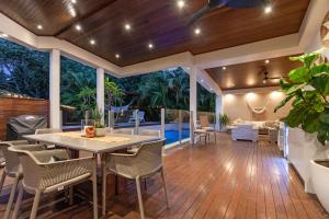 a patio with a table and chairs on a deck at Relaxed Luxury In Paradise - A touch of Breeze! in Sunrise Beach