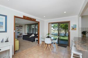 cocina y sala de estar con mesa y sillas en Francis 31, en Port Macquarie