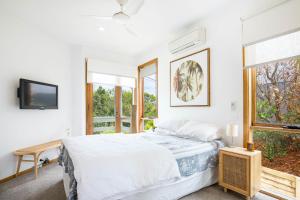 Habitación blanca con cama y ventana en Maldas Retreat Pet Friendly Absolute Beachfront with Spa en Culburra Beach
