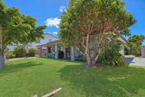 una casa con un árbol en el patio en Francis 31, en Port Macquarie