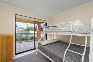 a bedroom with two bunk beds and a balcony at Pacific 1 in Port Macquarie