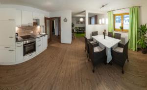 uma cozinha e sala de estar com mesa e cadeiras em Appartements Haidl em Sankt Johann im Pongau