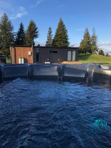 a pool of water in front of a house at Fairway Cottages in Rotorua