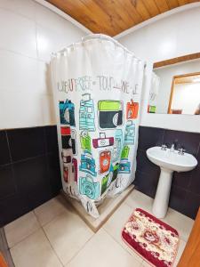zasłona prysznicową w łazience z umywalką w obiekcie Departamentos Copos de Nieve w mieście El Bolsón