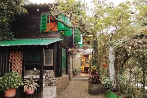 a house with a green door and a tree at Chalet a orillas del rio Pance in Cali