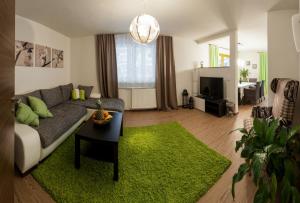 a living room with a couch and a green rug at Appartements Haidl in Sankt Johann im Pongau