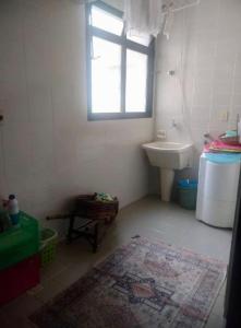 uma casa de banho com um lavatório, um WC e uma janela. em Frente ao Mar Del Plata em São Vicente