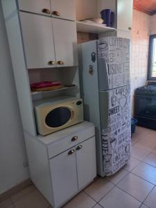 a kitchen with a microwave and a refrigerator at Departamento Céntrico in Posadas