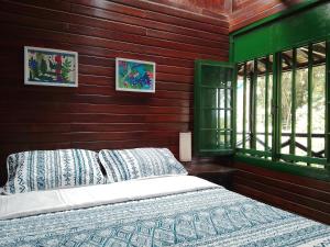 1 dormitorio con 1 cama y pared de madera en Chalet a orillas del rio Pance en Cali