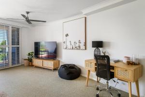 Habitación con escritorio, TV y silla. en Flightdeck 203 5-7 Clarence Street PM, en Port Macquarie
