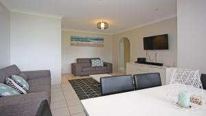 ein Wohnzimmer mit Sofa und Tisch in der Unterkunft Flynns View 8 in Port Macquarie