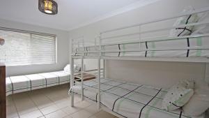 ein Schlafzimmer mit zwei Etagenbetten und einem Fenster in der Unterkunft Flynns View 8 in Port Macquarie