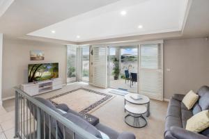 - un salon avec un canapé et une télévision dans l'établissement 22 The Promenade, à Port Macquarie