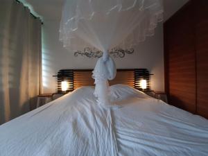 a white dress on top of a bed at Appartement le Marin avec vue sur mer in Le Marin