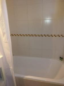 y baño con bañera blanca y cortina de ducha. en Villa Catedral en San Carlos de Bariloche