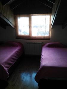 Duas camas num quarto com uma janela em Villa Catedral em San Carlos de Bariloche