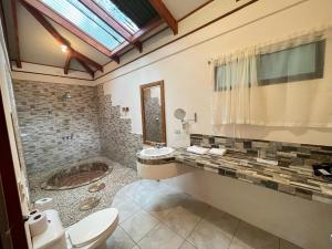 a bathroom with a toilet and a sink and a tub at Hotel Cerro Lodge in Tárcoles +133 photos