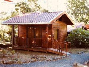 a log cabin with a porch and a deck at Cabañas San gerardo in San Gerardo de Dota