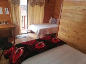 a bedroom with a bed with red roses on it at Cabañas San gerardo in San Gerardo de Dota