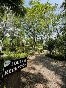 a sign that says lobby evacuation in a forest at Hotel Cerro Lodge in Tarcoles