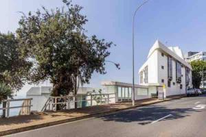 uma rua com um edifício branco e uma árvore em Studio Bondi Beach em Sydney