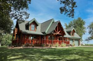a log cabin with a porch and a large yard at Rustic Cabin with seasonal Pool & Fire Pit - close to to Bike Path in Celina