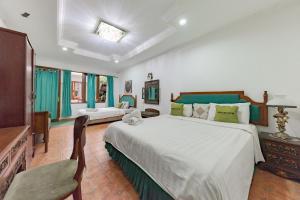 a large bedroom with a large bed and a tv at Urbanview De Ethnic Hotel Bandung in Bandung