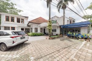 a white car parked in front of a house at Urbanview De Ethnic Hotel Bandung in Bandung