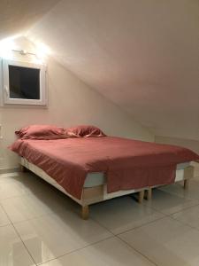 - un lit avec une couette rouge dans l'établissement Superbe appartement parking gratuit 2, à Aulnay-sous-Bois