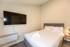 Schlafzimmer mit einem Bett und einem Flachbild-TV in der Unterkunft Eliza Lee 2 50 Gippsland Street in Jindabyne