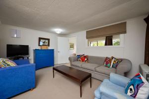 a living room with a couch and a tv at Views on Scarborough in Kaikoura